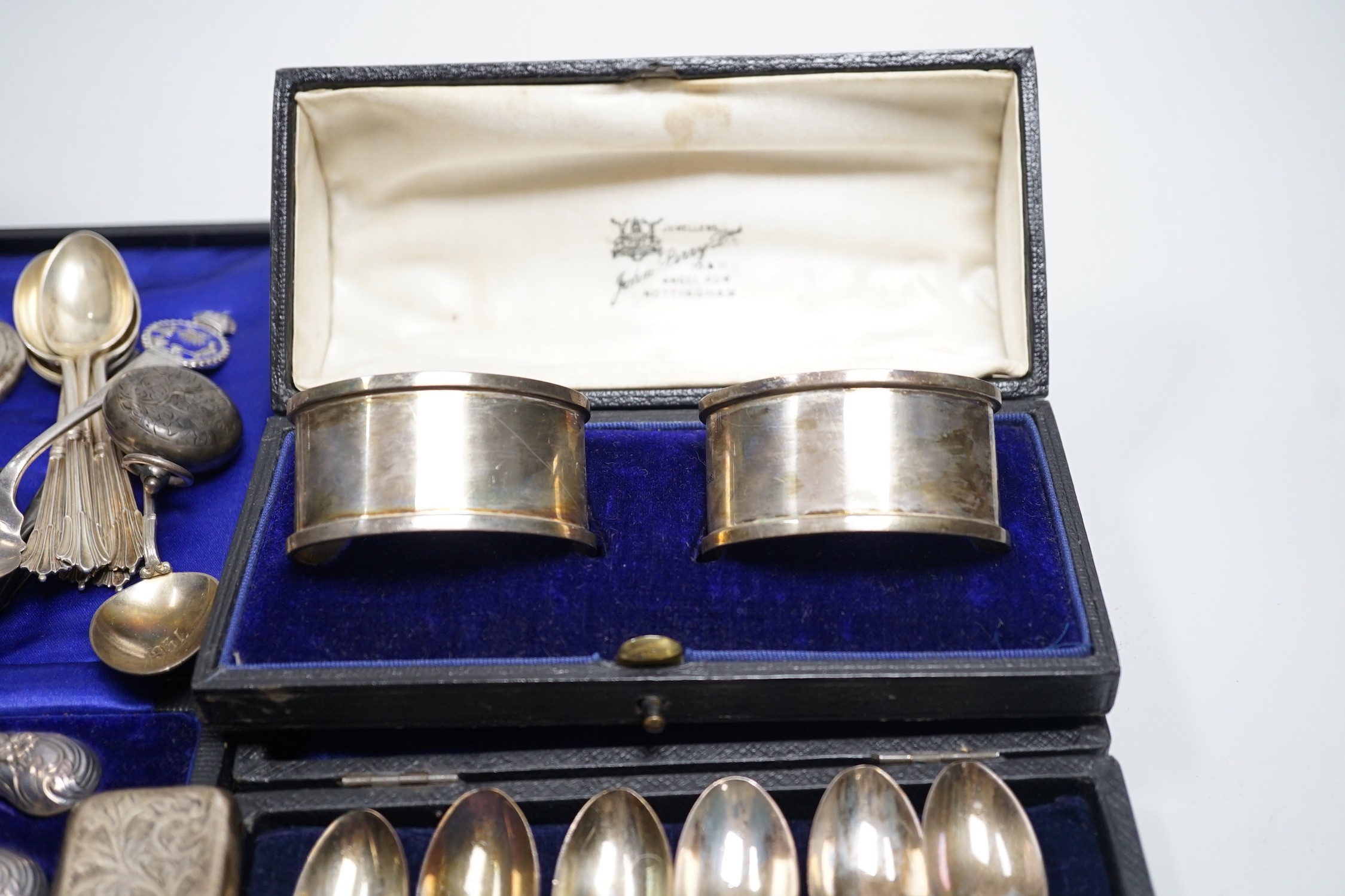 A mixed group of assorted silver ware including a pair of vases, 13.1cm, weighted, cased and loose napkin rings, cased teaspoons, cased silver pistol handled tea knives, sovereign case, mother of pearl handled fruit knif